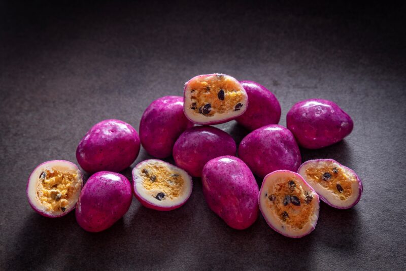 Chocolate-coated freeze-dried passionfruit with dragon fruit purple coating made by Noosa Chocolate Factory